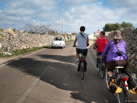 cykeltur på landsvägar med stenmurar och vintage bilar